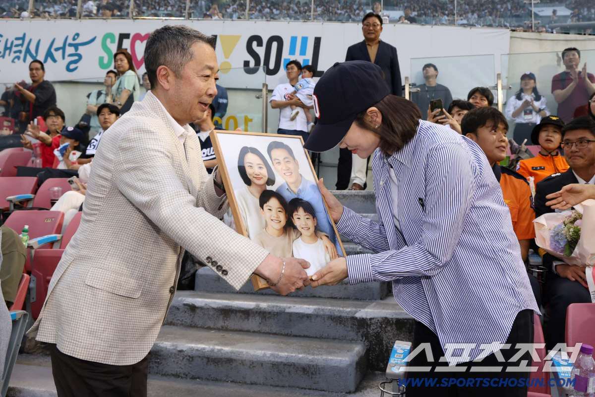박정원 두산그룹 회장이 지난해 6월24일 '두산베어스 소방가족의 날'을 맞아 2018년 순직한 故심문규 소방장 유가족에게 AI 복원 가족사진 및 기념품 전달하고 있다.