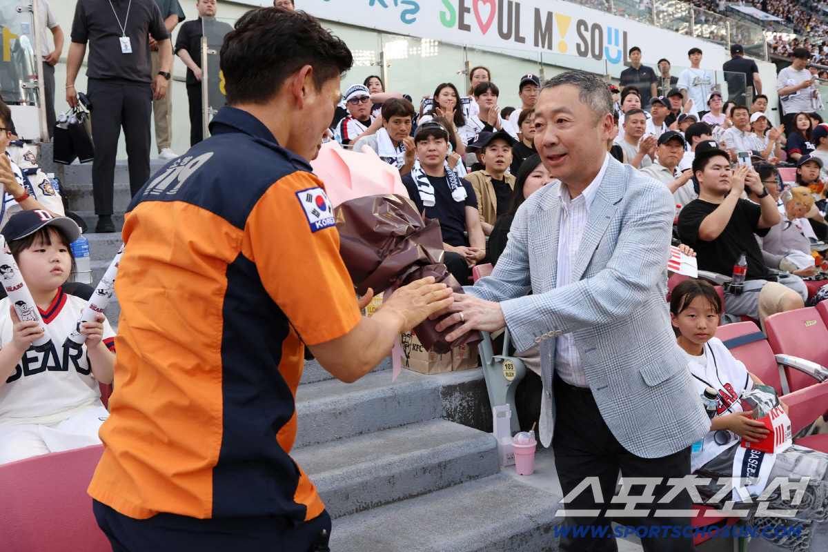 박정원 두산그룹 회장이 2024년 6월19일 '두산베어스 소방가족의 날'을 맞아 서울119 특수구조단 한정민 팀장에게 꽃다발을 건네고 있다.
