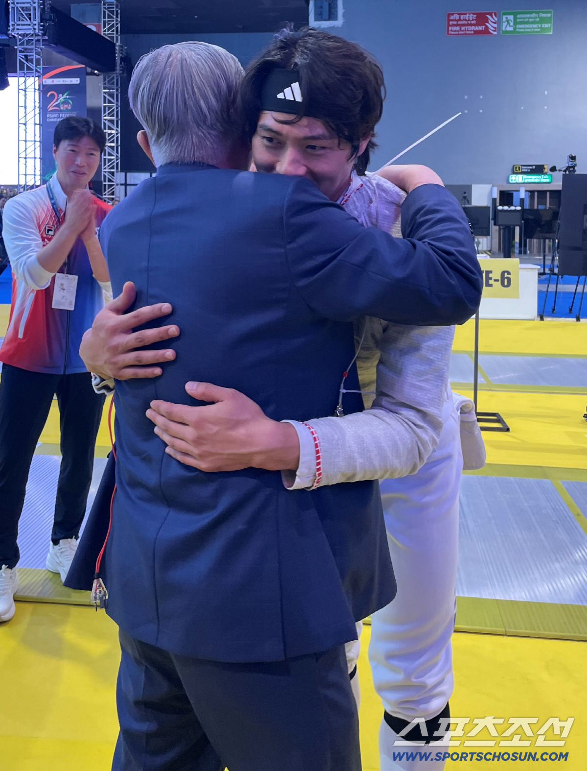 이날도 어김없이 1열에서 직관 응원한 최신원 대한펜싱협회장이 오상욱을 따뜻하게 끌어안으며 격려하는 모습. 원우영 대표팀 코치가 박수를 보내고 있다. 사진제공=대한펜싱협회