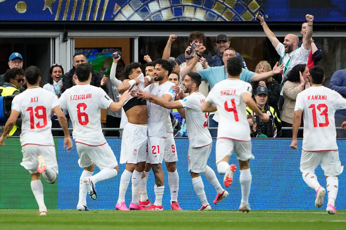 Iran's Ramin Rezaeian (23), center left, celebrates with teammates after scoring his side's opening goal during the World Cup Group G soccer match between Egypt and Iran in Seattle, Friday, June 26, 2026. (AP Photo/Lindsey Wasson)