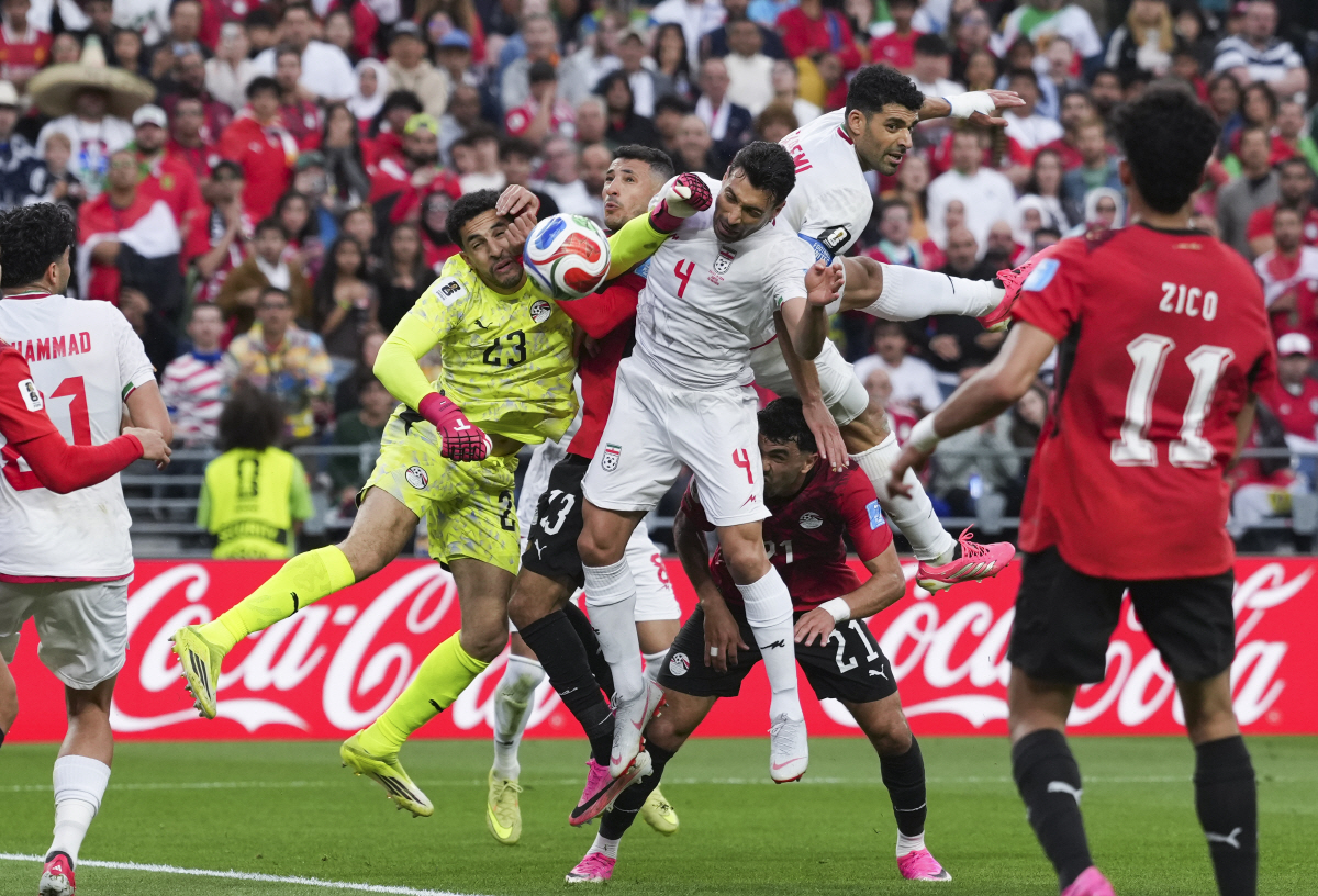 (260627) -- SEATTLE, June 27, 2026 (Xinhua) -- Mostafa Shoubir, goalkeeper of Egypt, and Shoja Khalilzadeh (No. 4) of Iran fight for the ball during the group G match between Egypt and Iran at the 2026 FIFA World Cup at Seattle Stadium in Seattle, the United States, June 26, 2026. (Xinhua/Peng Ziyang)