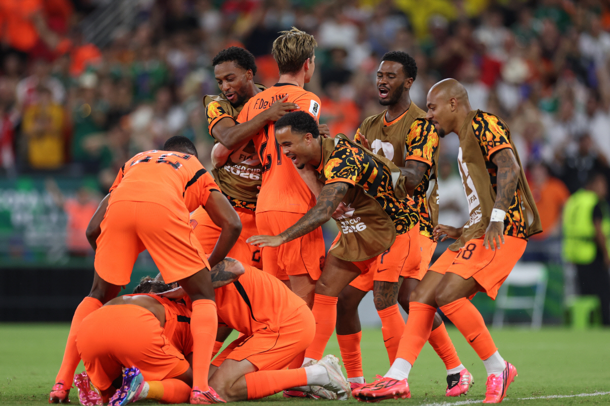 Netherlands' Cody Gakpo (11) (on the ground, left) gets surrounded by teammates after scoring the first goal during the World Cup round of 32 soccer match between the Netherlands and Morocco in Guadalupe, near Monterrey, Mexico, Monday, June 29, 2026. (AP Photo/Sofia Yaker)