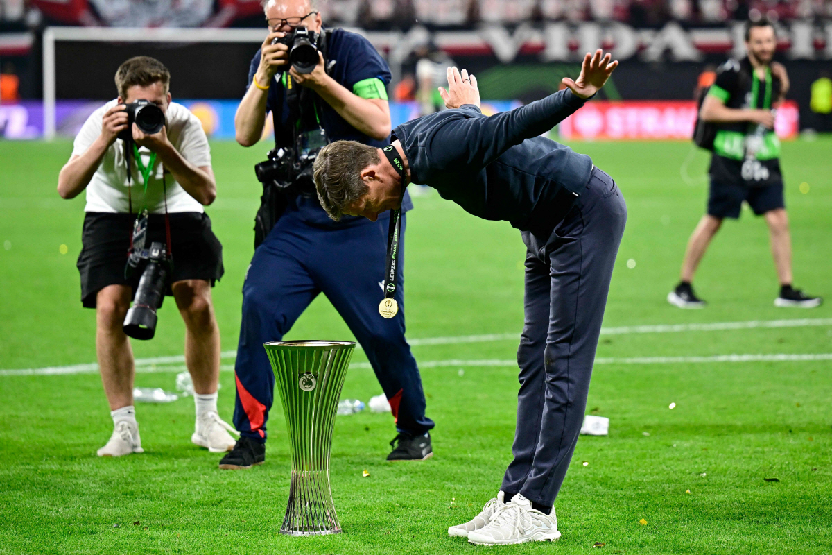 TOPSHOT - Crystal Palace's Austrian manager Oliver Glasner bows to the trophy after his team won the UEFA Conference League final football match between Crystal Palace FC and Rayo Vallecano de Madrid in Leipzig, eastern Germany, on May 27, 2026. (Photo by Tobias SCHWARZ / AFP)