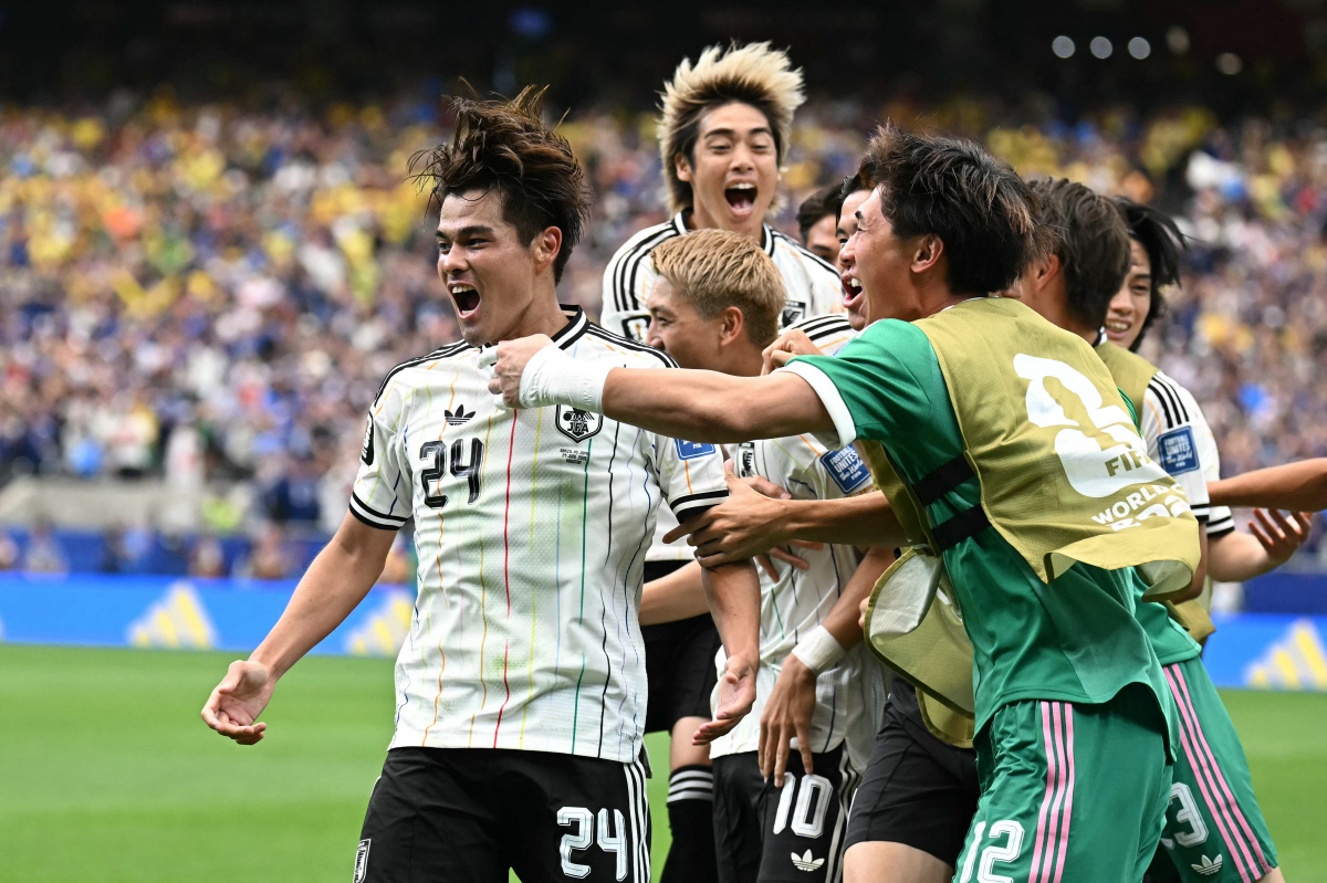 TOPSHOT - Japan's midfielder #24 Kaishu Sano (L) celebrates with teammates after scoring the opening goal during the 2026 World Cup round of 32 football match between Brazil and Japan at the Houston Stadium in Houston on June 29, 2026. (Photo by Paul ELLIS / AFP)
