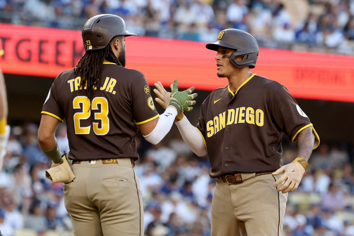 Jul 5, 2026; Los Angeles, California, USA; San Diego Padres right fielder Fernando Tatis Jr. (23) greets third baseman Manny Machado (13) after he hit a 3-run home run in the seventh inning against the Los Angeles Dodgers at Dodger Stadium. Mandatory Credit: Kiyoshi Mio-Imagn Images