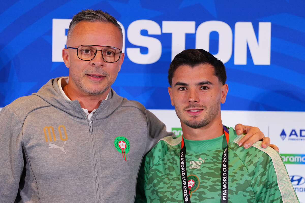 Morocco head coach Mohamed Ouahbi stands with Morocco's Brahim Diaz for a photo after a press conference ahead of the World Cup quarterfinal soccer match between France and Morocco in Foxborough, Mass., near Boston, Wednesday, July 8, 2026. (AP Photo/Martin Meissner)