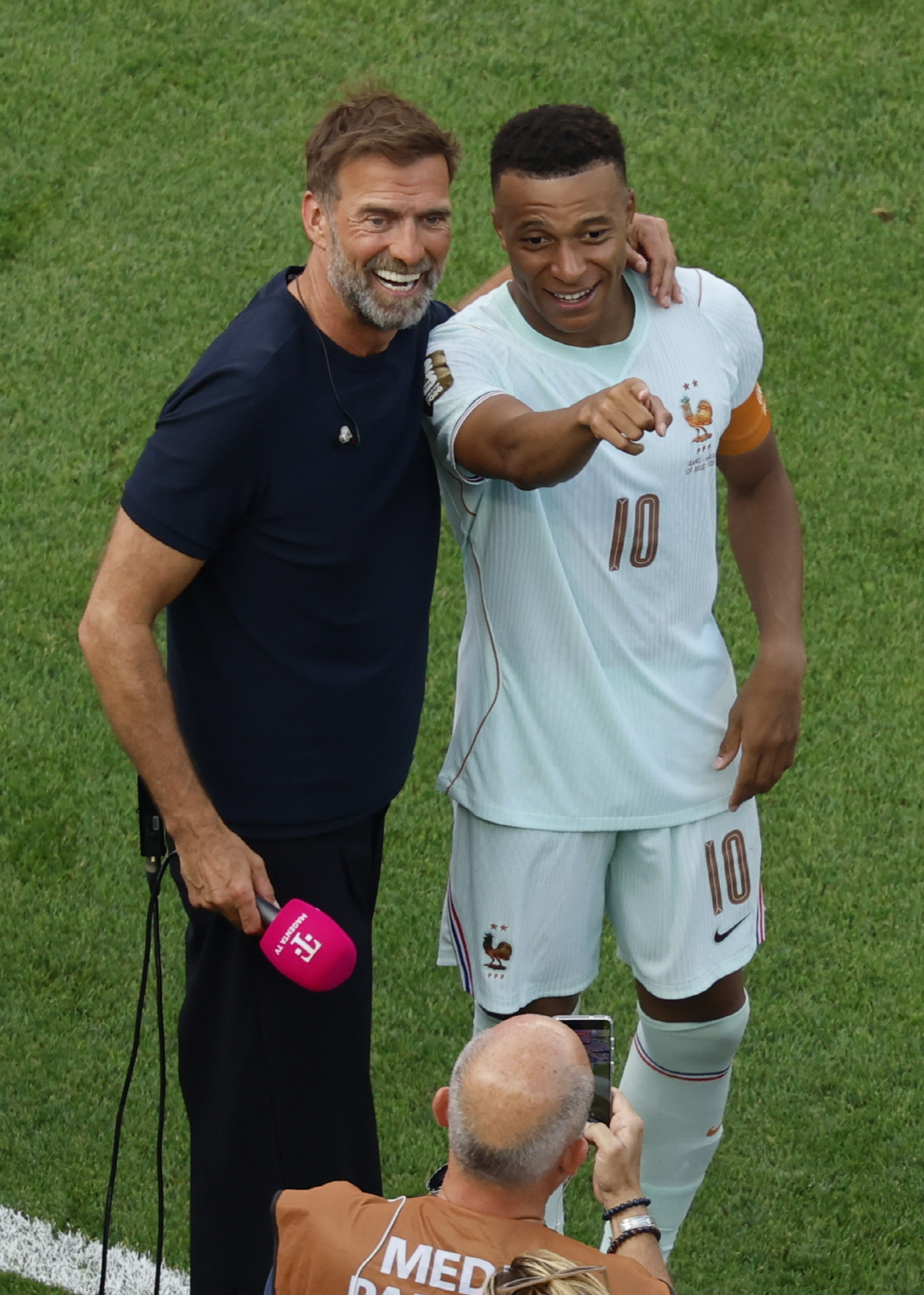 epa13101427 Kylian Mbappe of France (R) and German TV pundit Juergen Klopp share a light moment after winning the FIFA World Cup 2026 quarterfinals match France against Morocco, in Boston, USA, 09 July 2026. EPA/GREG M. COOPER