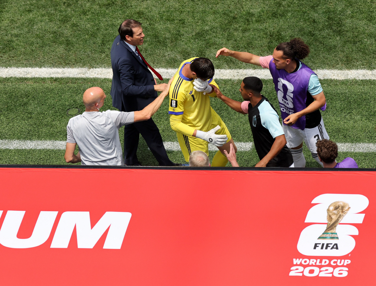 INGLEWOOD, CALIFORNIA - JULY 10: Rudi Garcia, Head Coach of Belgium, and teammates console Thibaut Courtois #1 as he is substituted during the FIFA World Cup 2026 Quarter Final match between Spain and Belgium at Los Angeles Stadium on July 10, 2026 in Inglewood, California. Alex Grimm/Getty Images/AFP (Photo by ALEX GRIMM / GETTY IMAGES NORTH AMERICA / Getty Images via AFP)