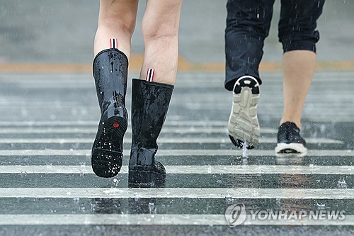(서울=연합뉴스) 서대연 기자 = 장맛비가 내린 9일 서울 서초구 대법원 인근에서 장화를 신은 시민이 길을 건너고 있다. 2026.7.9 dwise@yna.co.kr