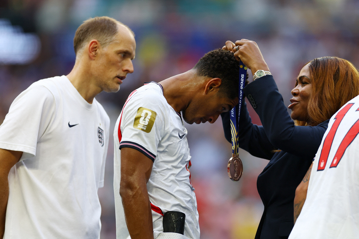 Soccer Football - FIFA World Cup 2026 - Bronze Final - France v England - Miami Stadium, Miami Gardens, Florida, U.S. - July 18, 2026 England's Jude Bellingham receives his bronze medal during the ceremony after the match as manager Thomas Tuchel looks on REUTERS/Carlos Barria