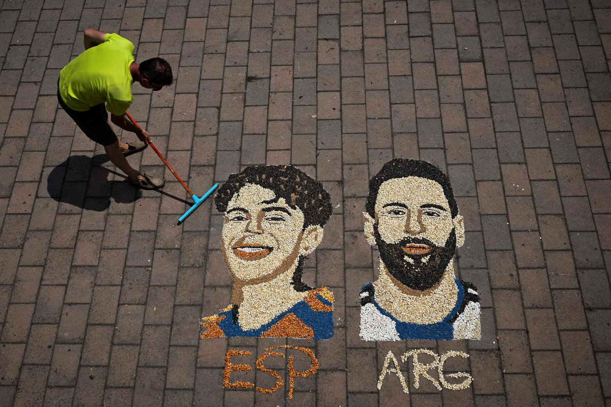 Kosovar artist Alkent Pozhegu puts the finish touches to a mosaic on the ground, made with grain and seeds, and depicting Argentina's forward #10 Lionel Messi (R) and Spain's forward #19 Lamine Yamal, in the town of Gjakova on July 16, 2026. Thousands of kilometres away from New York, where the Argentina and Spain football teams will compete for the World Cup title, in the western city of Gjakova, Alkent Pozhegu has made a mosaic depicting the two forward stars Lionel Messi and Lamine Yamal. (Photo by Armend NIMANI / AFP) / RESTRICTED TO EDITORIAL USE - MANDATORY MENTION OF THE ARTIST UPON PUBLICATION - TO ILLUSTRATE THE EVENT AS SPECIFIED IN THE CAPTION