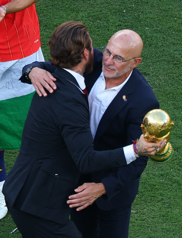 Soccer Football - FIFA World Cup 2026 - Final - Spain v Argentina - New York/New Jersey Stadium, East Rutherford, New Jersey, U.S. - July 19, 2026 Former Spain player Sergio Ramos congratulates coach Luis De La Fuente as he holds the World Cup trophy ahead of the trophy ceremony REUTERS/Mike Segar