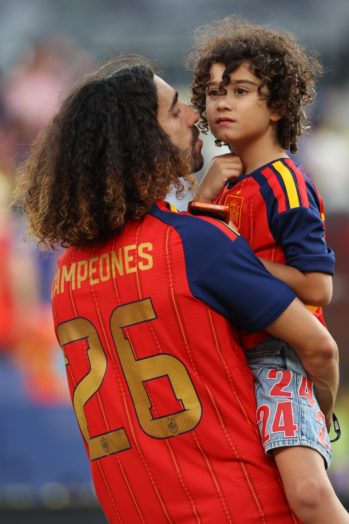 Spain's Marc Cucurella holds a kid after Spain won the World Cup final soccer match between Spain and Argentina in East Rutherford, N.J., near New York, Sunday, July 19, 2026. (AP Photo/Pamela Smith)