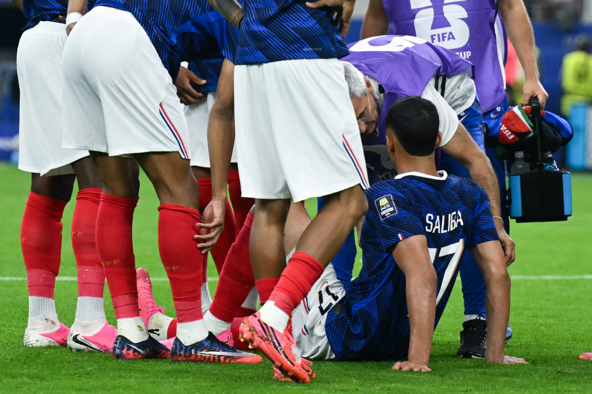 France's defender #17 William Saliba (R) receives medical attention as he sits injured on the pitch during the 2026 World Cup football tournament semi-final match between France and Spain at the Dallas Stadium in Arlington on July 14, 2026. (Photo by RONALDO SCHEMIDT / AFP)